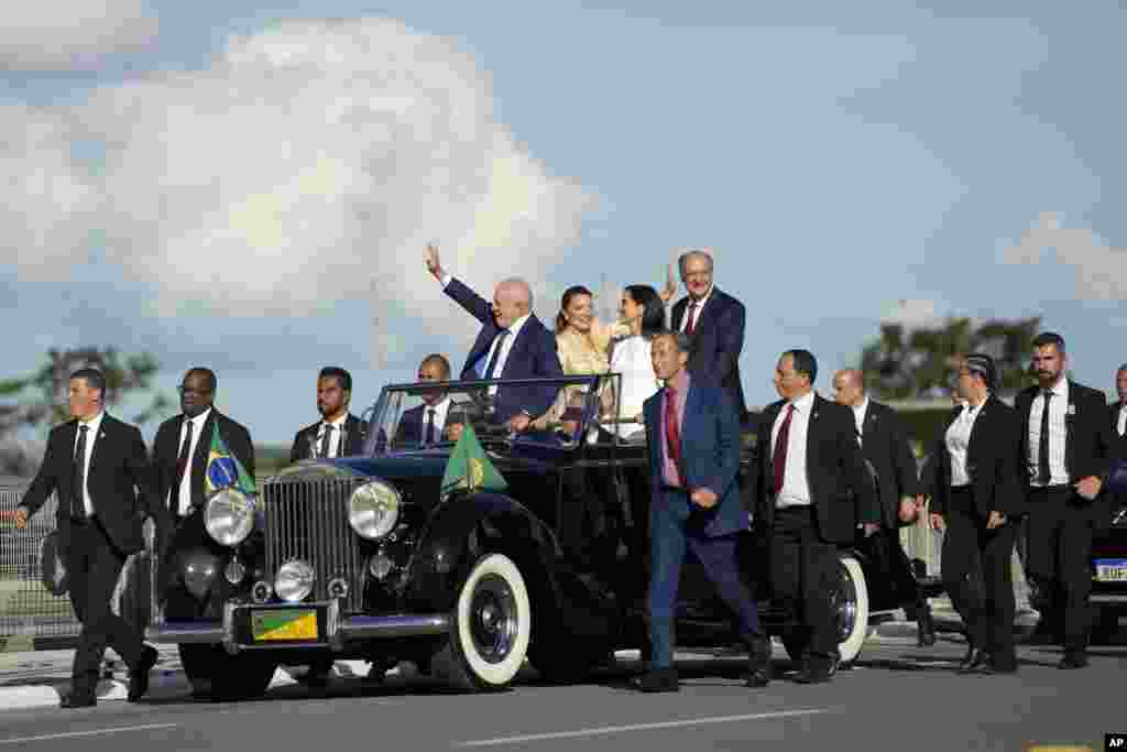 President Luiz Inacio Lula da Silva, left, his wife Rosangela Silva, center left, Vice President Geraldo Alckmin, right, and his wife Maria Lucia Ribeiro wave to supporters as they head to the Planalto Palace in Brasilia, Jan. 1, 2023.