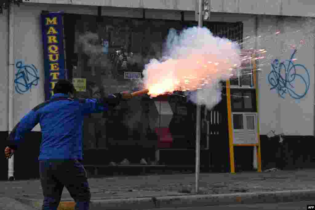 A supporter of the ruling Movement To Socialism fires a petard to opposers to President Luis Arce during a protest march "for democracy, freedom, and justice," demanding the release of the governor of Santa Cruz, Luis Fernando Camacho, in La Paz, Bolivia, Jan. 10, 2023.