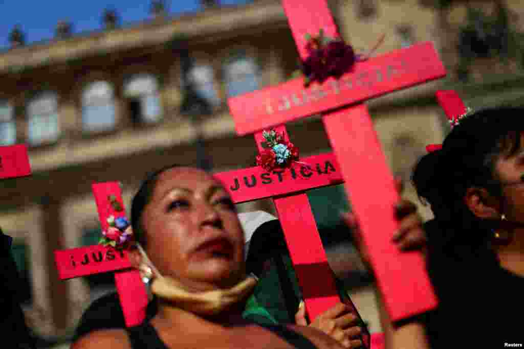 Mujeres sostienen cruces en una protesta contra el feminicidio y la violencia contra las mujeres frente al Palacio Nacional en la Ciudad de México. 