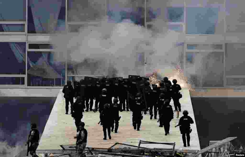 Security forces confront supporters of Brazil's former President Jair Bolsonaro protest against President Luiz Inacio Lula da Silva, in Planalto Palace, in Brasilia, Jan. 8, 2023.