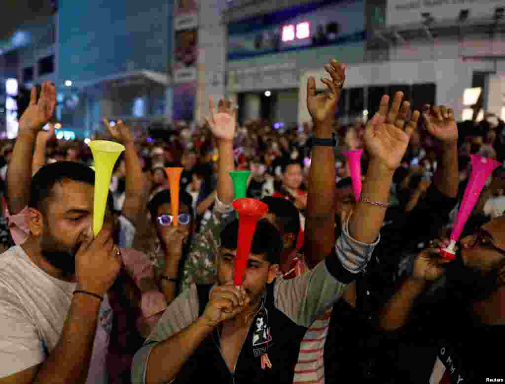 Revelers blow horn as they celebrates New Year's Eve in Kuala Lumpur, Malaysia, Dec. 31, 2022.