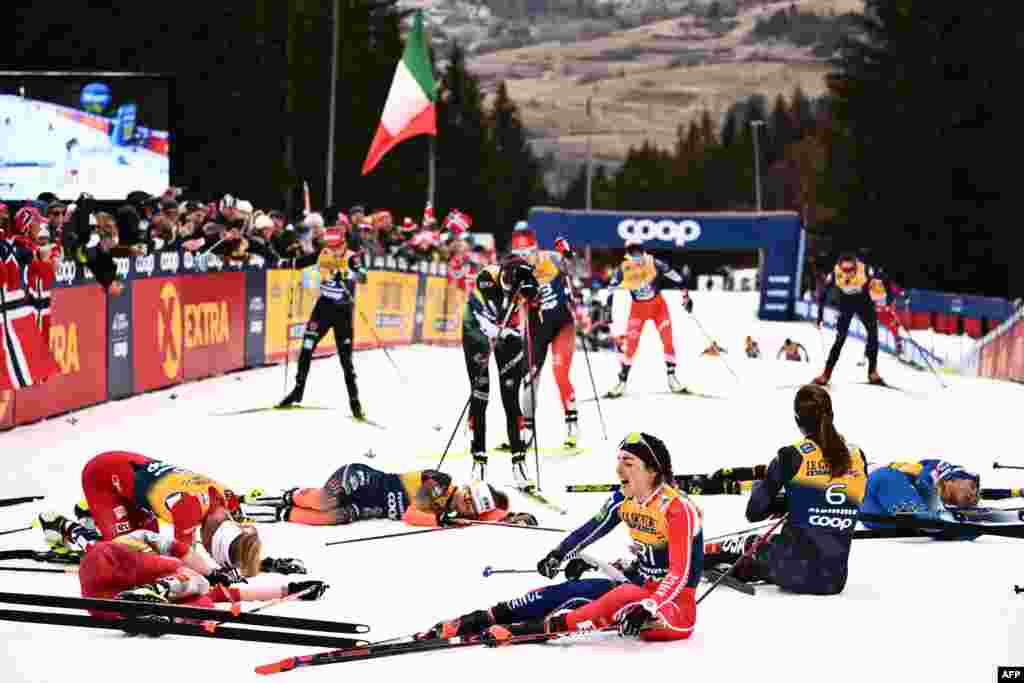 France's Juliette Ducordeau (Front R) and fellow athletes react after crossing the finish line of the Women's Mass Start 10 km Free event at the FIS Tour de Ski stage in Val di Fiemme, Italy.