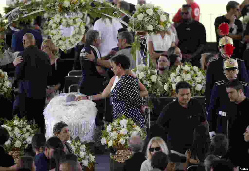 Pele's daughter, Kelly Cristina Nascimento, is seen next to the body of Brazilian soccer legend Pele in his casket, as he lays in state on the pitch of his former club Santos' Vila Belmiro Stadium in Santos.