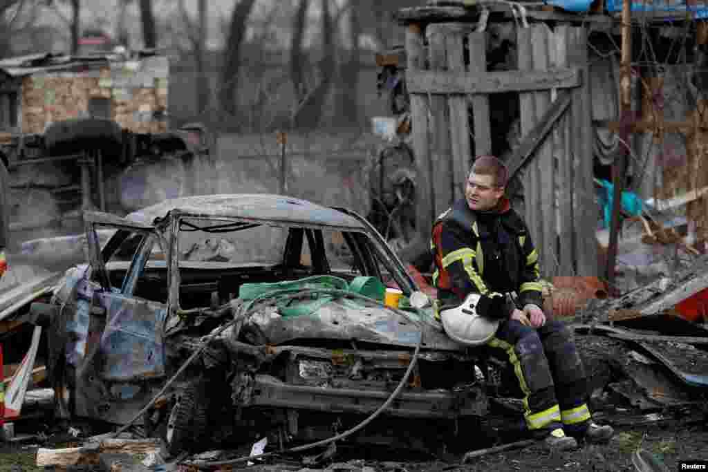 A rescuer rests at a residential house damaged during a Russian missile strike, amid Russia's attack on Ukraine, in Kyiv, Ukraine.
