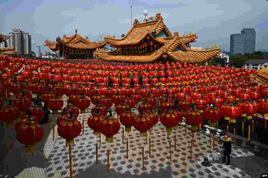 A cleaner cleans the floor under the red lanterns of Chinese New Year decorations at the Thean Hou Temple ahead of the Lunar New Year celebrations, which mark the year of the rabbit, in Kuala Lumpur, Malaysia.