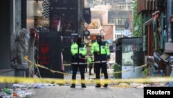 Policías protegen sitio de una estampida en Seúl, Corea del Sur, durante las festividades de Halloween en que murieron 158 personas, el 30 de octubre de 2022.
