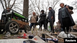 Los residentes locales esperan que sus dispositivos se carguen desde un generador portátil en un mercado local durante el conflicto Ucrania-Rusia en la ciudad portuaria sureña de Mariúpol, Ucrania, el 19 de abril de 2022.