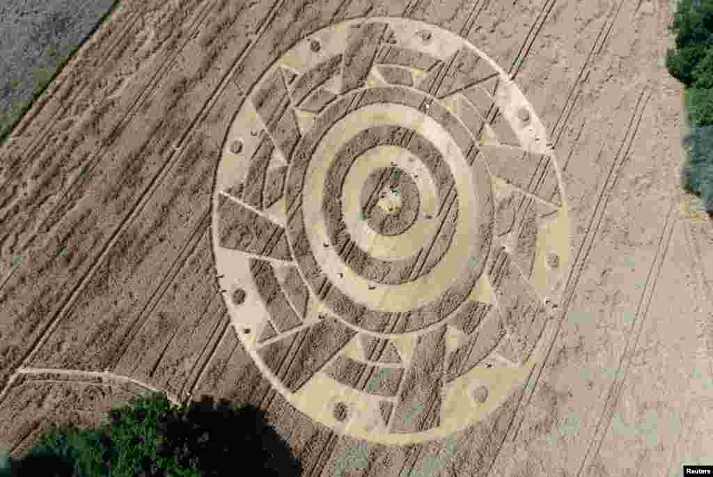 Visitors walk inside a crop circle in a wheat field near Paehl am Ammersee, Germany.