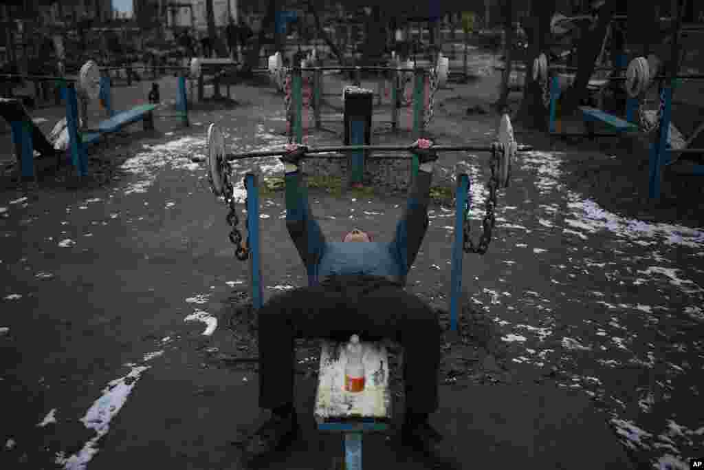 A man exercises at the Kachalka outdoor gym on Dolobetskyi island in the Dnieper River in Kyiv, Ukraine.