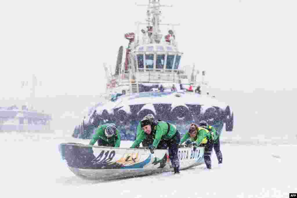 A team pushes their canoe on the ice during the Quebec Winter Carnival Ice Canoe Race in Quebec City, Canada, Feb. 5, 2023.