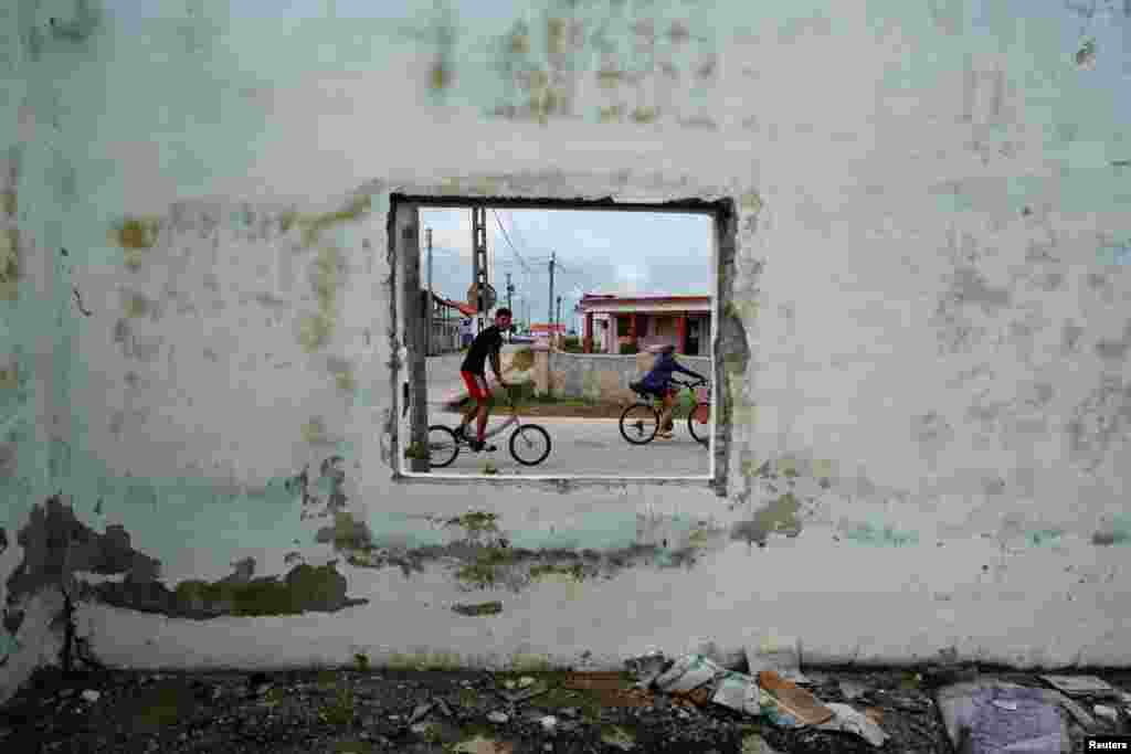 Children riding bicycles pass by an abandoned building in Isabela de Sagua, Cuba. This far-flung peninsula - on Cuba's north-central coast just 130 miles (210 km) south of the Florida Keys - is poised to once again became a barometer for measuring the impact of U.S. immigration policy, said residents.