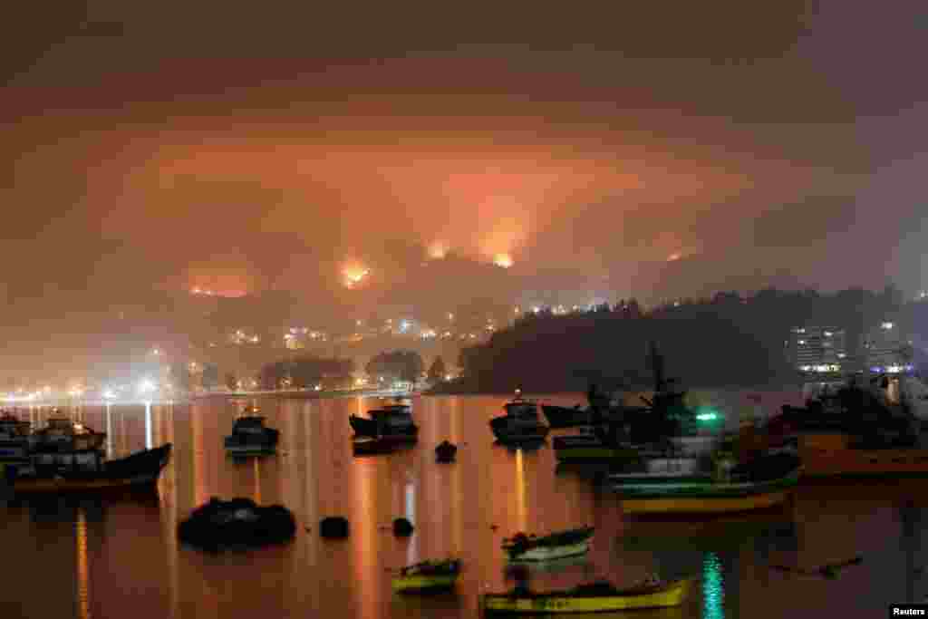 A wildfire burns areas in Dichato, near Concepcion, Chile. Firefighters were battled dozens of raging wildfires, seeking to gain control of one of the country's worst natural disasters in years as the death toll rose to at least 24 with nearly 1,000 more injured.