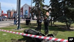 Wanajeshi wa Ukraine wakiwa pembeni ya kipande cha kombora la Tochka-U baada ya tukio la Russia kulipiga katika kituo cha reli huko mjini Kramatorsk, Ukraine, Ijumaa, April 8, 2022. (AP Photo/Andriy Andriyenko)