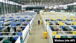 In this photo released by China's Xinhua News Agency, people with mild and asymptomatic cases of COVID-19 quarantine at the Shanghai New International Expo Center in Shanghai, Friday, April 1, 2022. (Ding Ting/Xinhua via AP)