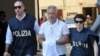 Italian police officers escort Francesco Inzerillo (C) after he was arrested in Palermo during an police/FBI operation called 'New Connection' on July 17, 2019. 