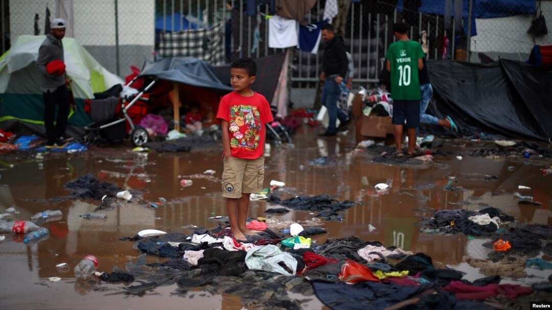 A migrant boy, part of a caravan of thousands from Central America trying to reach the United States, stands in a temporary shelter after heavy rainfall in Tijuana, Mexico, Nov. 29, 2018. The IOM says it has helped hundreds of migrants from the caravan return home.