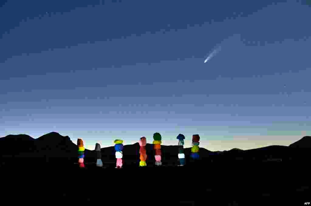 Comet NEOWISE or C/2020 F3 is seen in the sky, above the "Seven Magic Mountains" art installation by artist Ugo Rondinone, in Jean, Nevada, July 15, 2020.