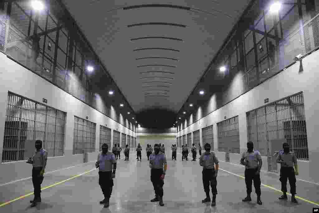 Civil guards from the General Directorate of Prisons stand outside holding cells at The Terrorism Confinement Center during a media tour in Tecoluca, El Salvador, Feb. 2, 2023. The "mega-prison" still under construction has a maximum capacity of 40,000 and is intended to imprison gang members, according to the government. 
