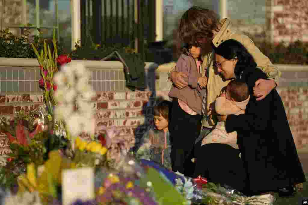 A family gathers at a memorial outside the Star Ballroom Dance Studio in Monterey Park, California, Jan. 24, 2023. A gunman killed multiple people at the ballroom dance studio late Saturday amid Lunar New Years celebrations in the predominantly Asian-American community.