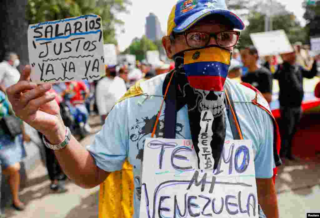 A demonstrator holds a sign that reads "Fair Salaries Now" during a march to demand better salaries in Caracas, Venezuela, as the government of President Nicolas Maduro faces renewed challenges in its attempt to fight inflation.