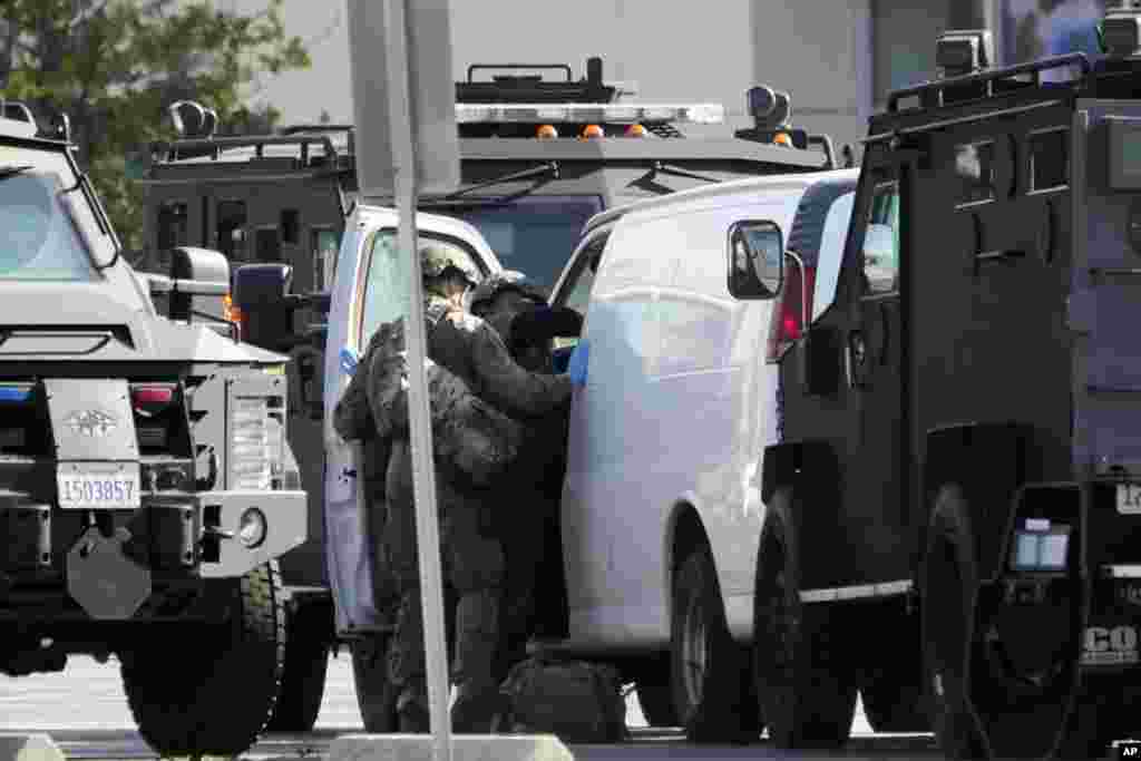 Members of a SWAT team enter a van in Torrance, California, Jan. 22, 2023. The hunt for a gunman who killed 10 people at a Los Angeles-area ballroom dance club ended when authorities found him dead of a self-inflicted gunshot wound in the van he used to flee after people thwarted his attempt at a second shooting.