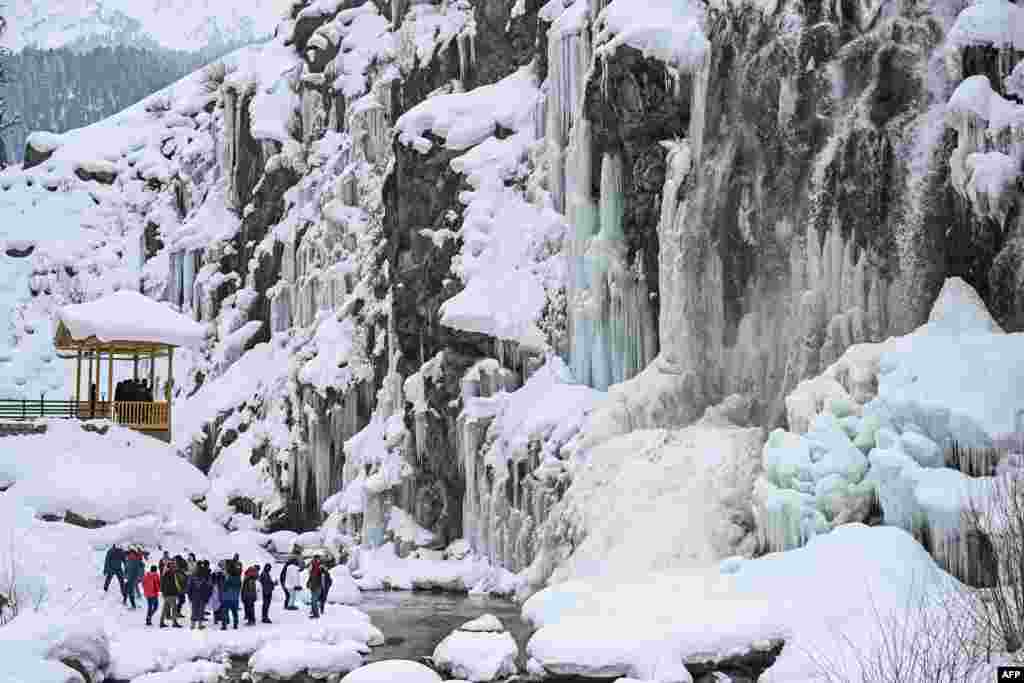 Tourists visit a frozen waterfall in the Drang area of Tangmarh, Indian-administered Kashmir.