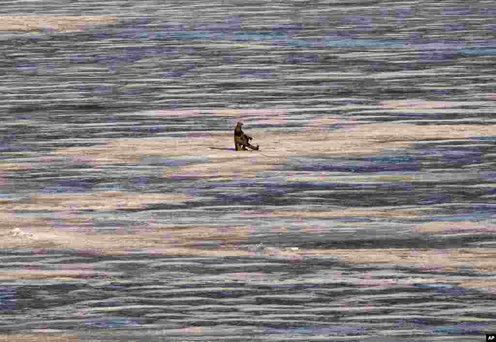 A fisherman enjoys ice fishing on the Dnipro river outside Kyiv, Ukraine.