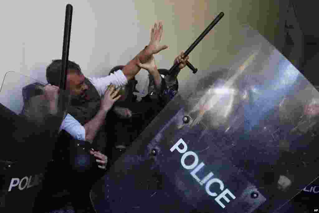 Anti-government protesters scuffle with riot police outside the ministry of Justice, in Beirut, Lebanon. Scores of protesters scuffled with riot police as they tried to break into the Beirut Justice Palace, rejecting an order from Lebanon's judiciary that further crippled the probe into a massive port explosion over two years ago.