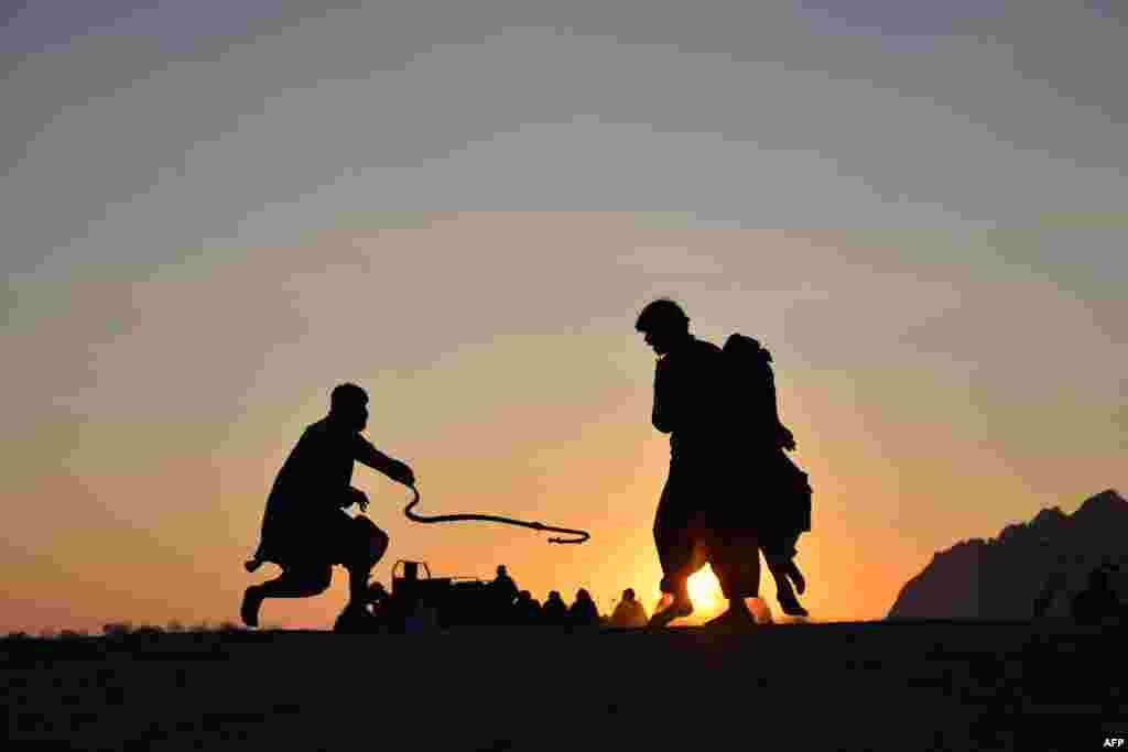 Afghan men play a traditional rope game 'Dora' along a field in Dand district of Kandahar province, Jan. 22, 2023.