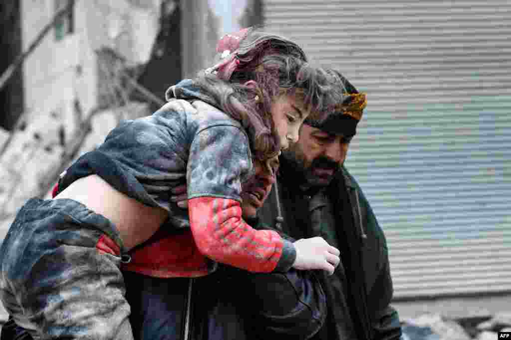 Residents carry an injured child from the rubble of a collapsed building following an earthquake in the town of Jandaris, in the countryside of Syria's northwestern city of Afrin in the rebel-held part of Aleppo province. Hundreds have been reportedly killed with hundreds more believed to be trapped under the rubble after a 7.8-magnitude earthquake rocked wide parts of Turkey and Syria.