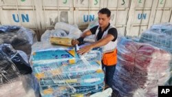 FILE - A United Nations worker prepares aid for distribution to Palestinians at a UNRWA warehouse in Deir Al-Balah, Gaza Strip, on Oct. 23, 2023.