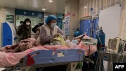 天津第一中心醫院的醫護人員在護理一名感染新冠的病人。（2022年12月28日）