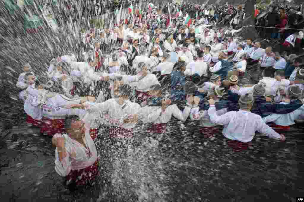 Bulgarian men perform the traditional "Horo" dance in the winter waters of the Tundzha river in the town of Kalofer, as part of Epiphany Day celebrations.