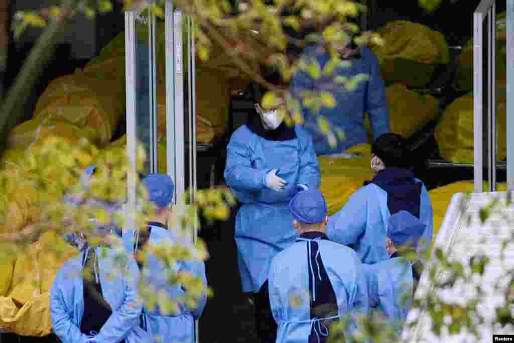 Staff members speak next to several body bags at a funeral home, as COVID-19 outbreaks continue in Shanghai, China, Jan. 4, 2023.