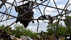 La gente limpia un área de un edificio dañado por un ataque con misiles durante la noche en Sloviansk, Ucrania, el 1 de junio de 2022.