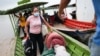 Migrantes venezolanos llegan en canoas a orillas del río Arauca del lado colombiano portando sus pertenencias tras huir de su país por operativos militares, según la agencia colombiana de migración, en Arauquita, el 27 de marzo de 2021.
