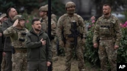 Ukrainian President Volodymyr Zelenskyy takes part in a national flag-raising ceremony in the recently retaken city of Izium, Ukraine, Sept. 14, 2022. 