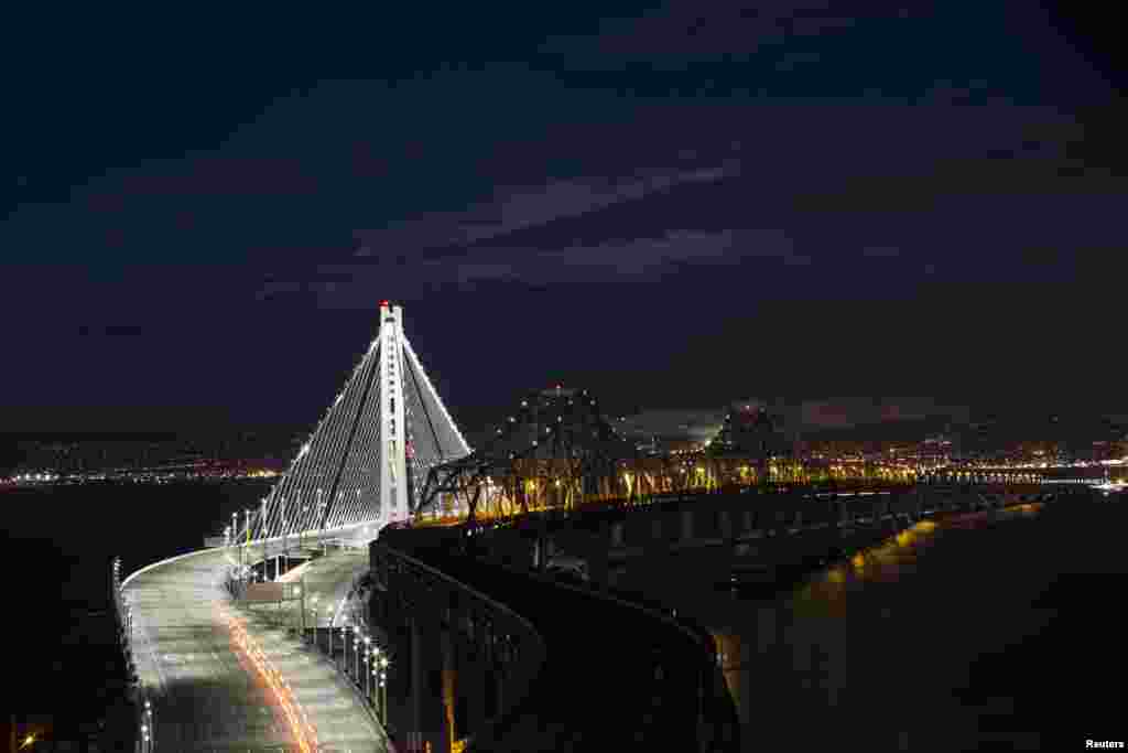 Lampu-lampu pada jembatan 'Bay' - yang menghubungkan kota San Francisco-Oakland - tampak menyala di kota San Francisco, negara bagian California, AS.