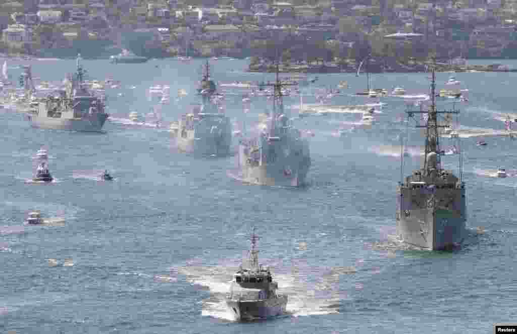 Royal Australian Navy warships led by HMAS Sydney (R) enter Sydney Harbor as part of the International Fleet Review celebrations. The Review marks the centenary of the first entrance into Sydney by the Royal Australian Navy's fleet, according to the Navy.