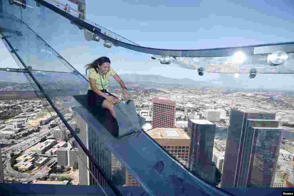 Sandra Brown naik Skyslide di antara lantai 69 dan 70 Menara Bank AS, U.S. Bank Tower, yang bersebelahan dengan dek observasi OUE Skyspace LA di tengah kota Los Angeles, California, 20 Juni 2016.