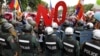 Police officers block a street as protesters march to the Cambodia National Assembly during a protest in Phnom Penh, July 13, 2015. 