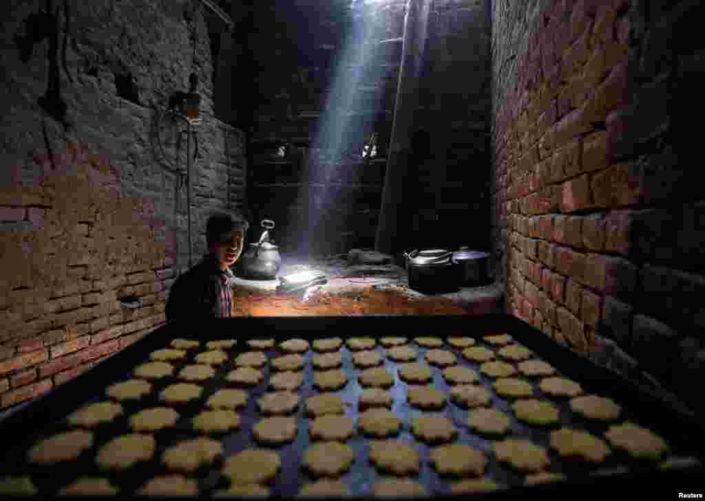 Seorang pria Afghanistan membuat kue-kue tradisional pada akhir bulan Ramadan dan menjelang perayaan Idul Fitri di Kabul.