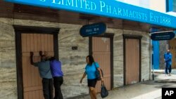 Residents board up a storefront pharmacy as they prepare for the arrival of Tropical Storm Dorian, in Bridgetown, Barbados, Monday, Aug. 26, 2019. Much of the eastern Caribbean island of Barbados shut down on Monday as Dorian approached the region…