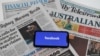 El logo de Facebook en una pantalla de celular sobre copias de diarios australianos, en Canberra Australia, este jueves 18 de febrero.