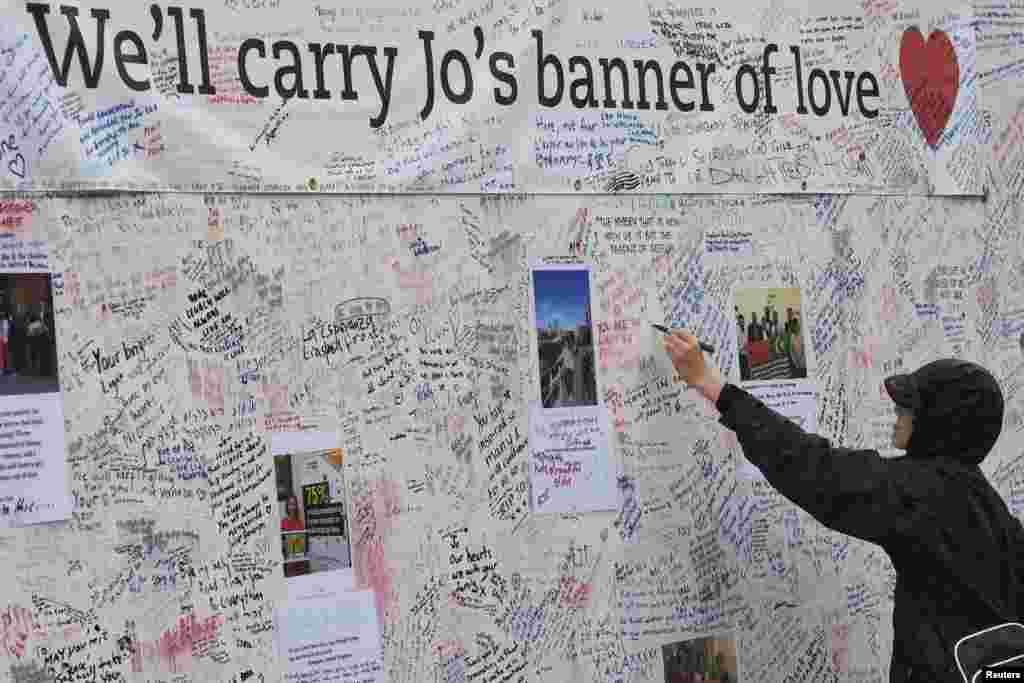 Seorang pria menuliskan pesan sebagai penghormatan terhadap anggota parlemen Inggris, Jo Cox, yang tewas ditembak di London, Inggris.