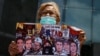 Una mujer sostiene un cartel con imágenes de personas que murieron durante las protestas del 2017, mientras asiste a una manifestación contra los cambios en las sanciones de Estados Unidos en Caracas, el 18 de mayo de 2022.