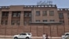 FILE - Afghan men walk past Da Afghanistan Bank, Afghanistan's central bank, in Kabul on June 28, 2011. 