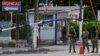 Custodios en la entrada principal del Hospital Naval en Guayaquil, donde fue llevado el exvicepresidente Jorge Glas el 8 de abril de 2024. Glas enfermó en una prisión tras su arresto durante una redada de la policía en la embajada de México en Quito.