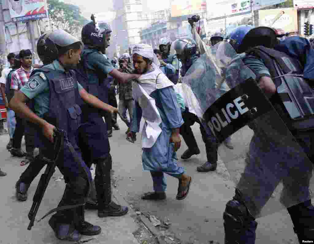 Police try to detain an activist of Hifazat-e-Islam during a clash in front of the national mosque in Dhaka, May 5, 2013.