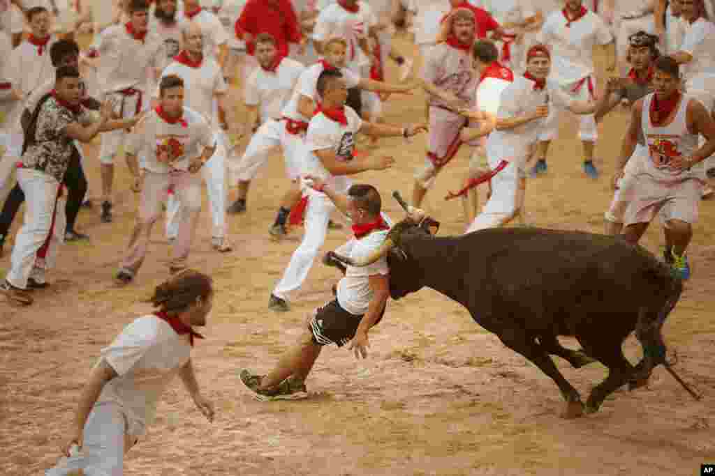 Seorang peserta festival ditanduk banteng pada festival lari dikejar banteng "San Fermin" di Pamplona, Spanyol.